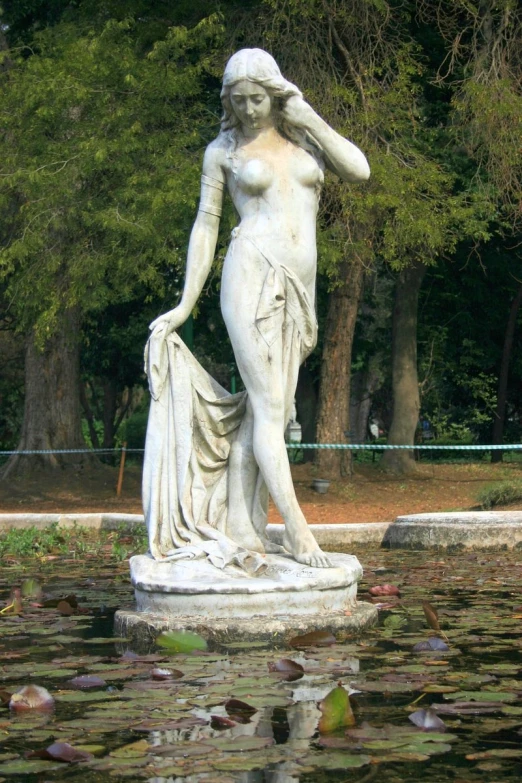 a woman is depicted in a statue by the water