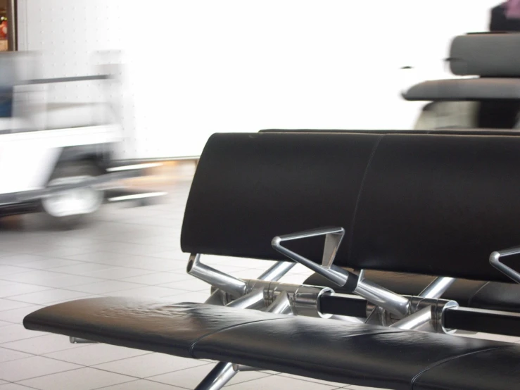 an airport waiting area with some black seats