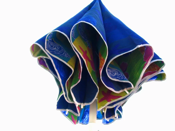 the colorful folded material is hanging off of a wire