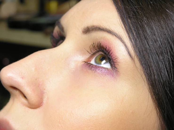 a close up of the face of a girl with eyeliner and lashes