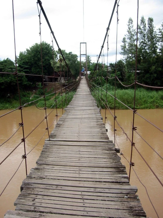 a wooden bridge spanning across a flooded river