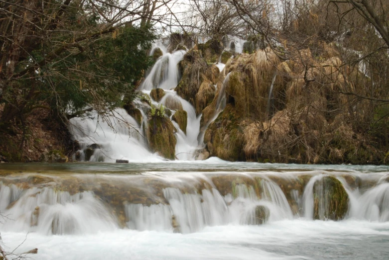 a small waterfall running over the rocks into a lake