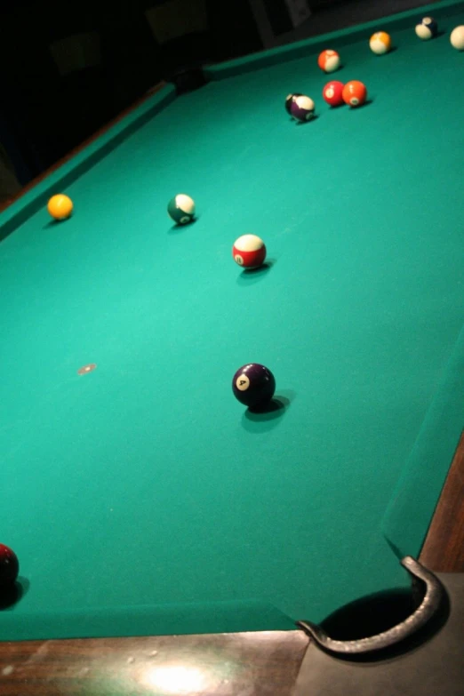 several different colored billiards are resting on the green cloth