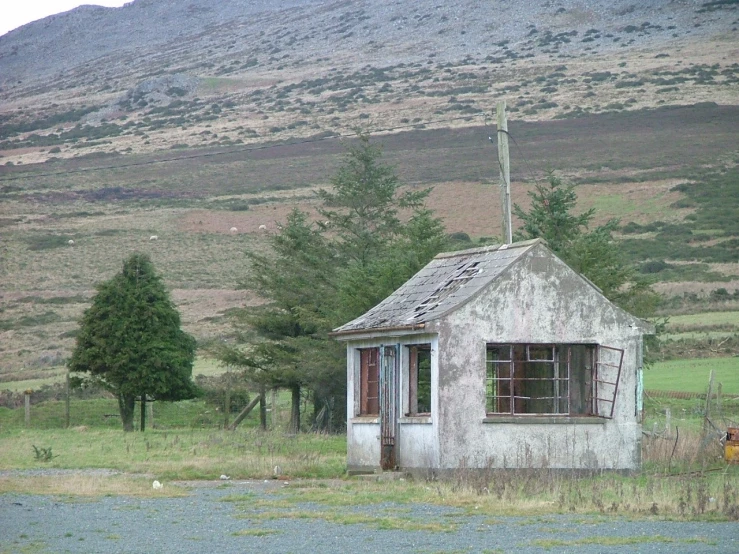 an old run down house with no roof sits in the countryside