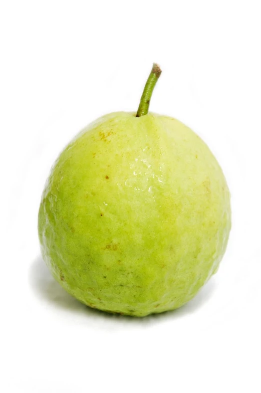 an apple with some green spots and one side has no leaves