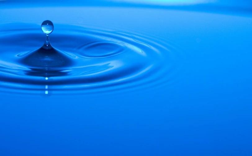 water drops into a pool, with blue background