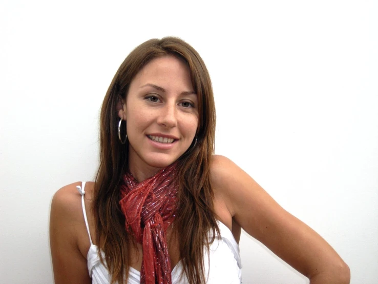 woman wearing a white tank top and red scarf posing for a po