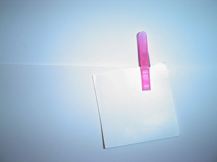 a pink pen sticking out of a piece of paper