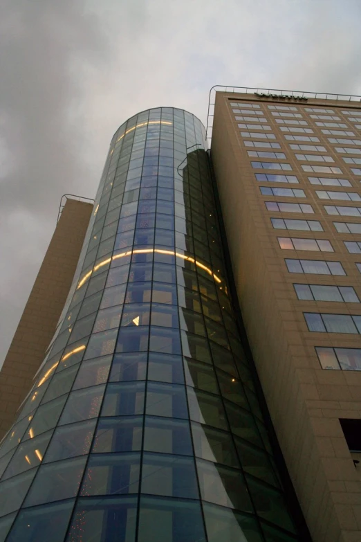 tall building with curved glass windows looking upward at the sky