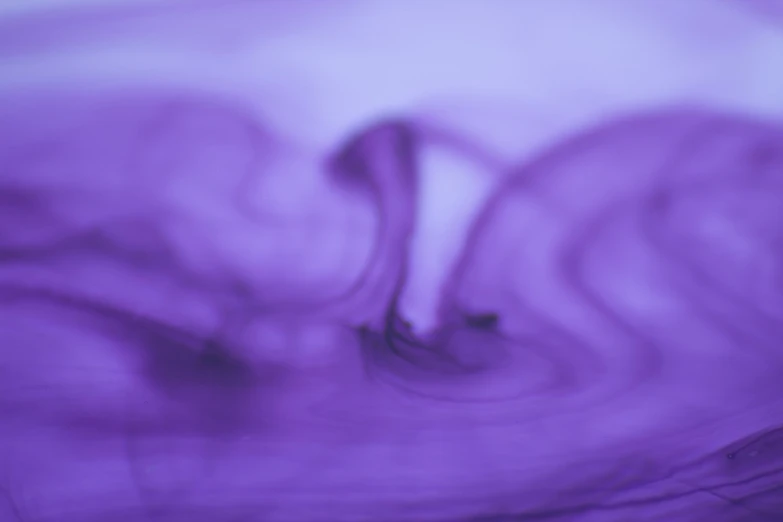 an abstract purple liquid substance with long wavy tails