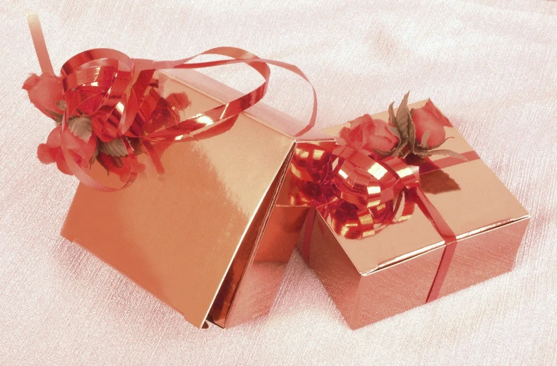 a pair of red boxes wrapped with red ribbon