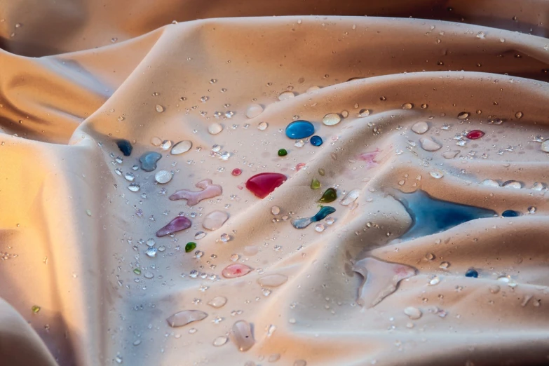 a po looking down at water drops and fabric