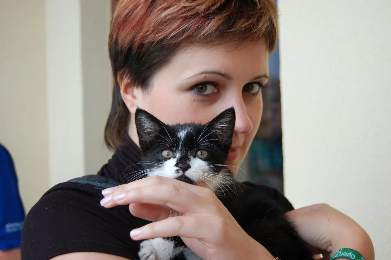 a woman holds up her cat for the camera