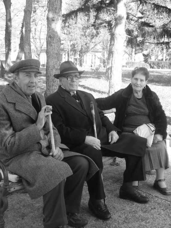 two women and a man are sitting together on a bench