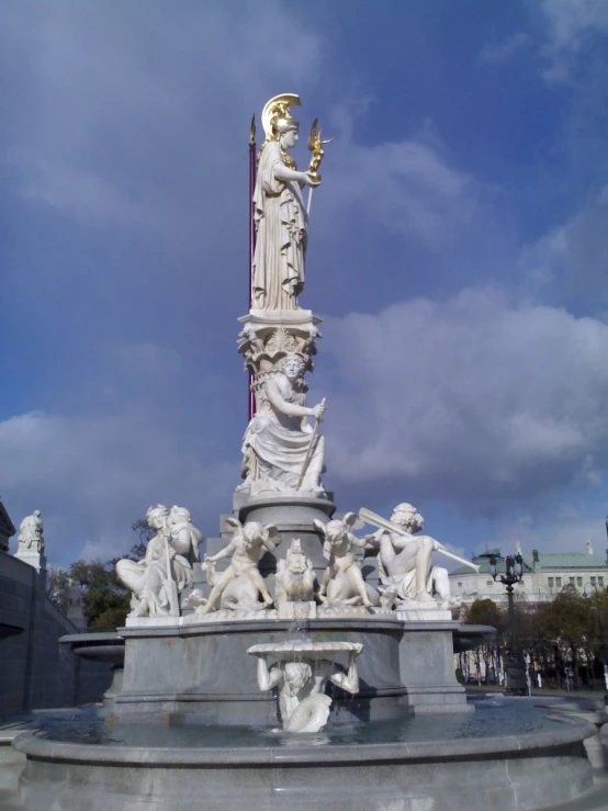 a white statue in front of a blue cloudy sky