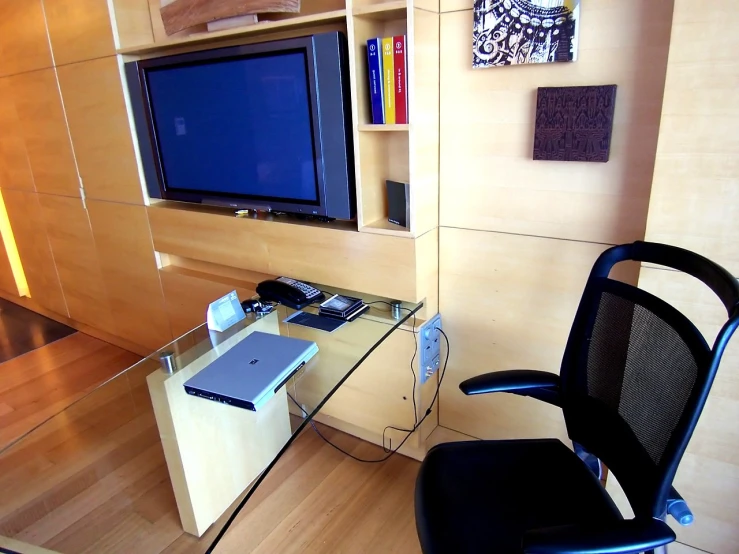 a office chair near a desk in front of a tv