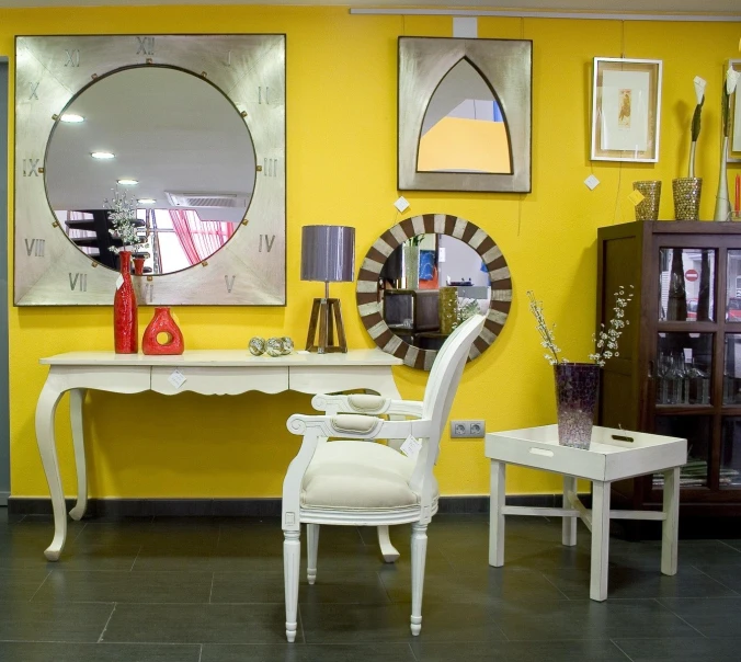 two white chairs are on the floor with yellow walls in the background