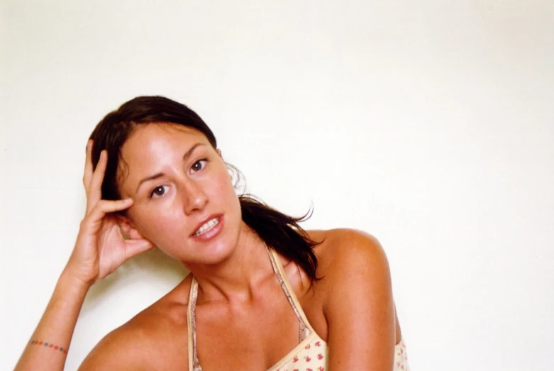 the girl poses in her swimsuit as she holds her hair