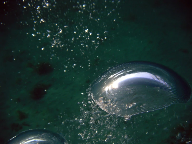 an aerial view of a shiny object floating on water