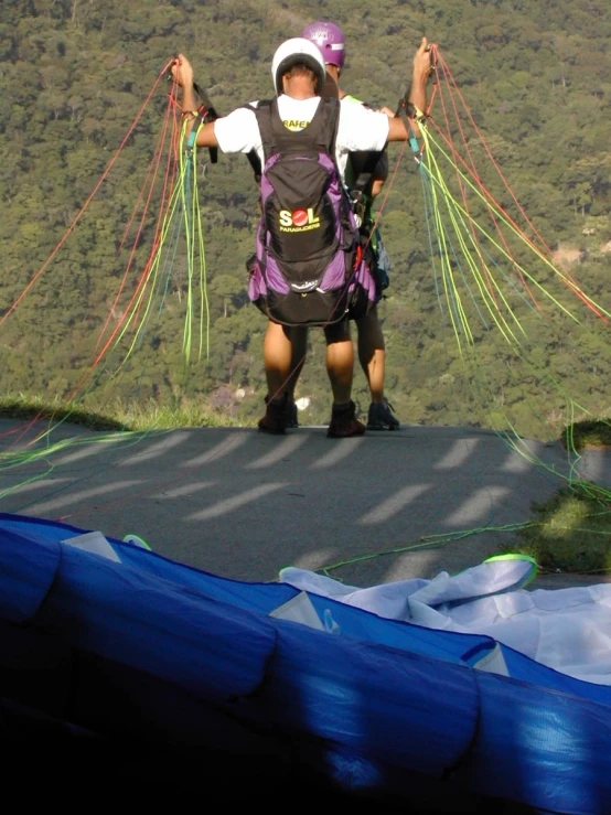 a person on a big hill with some parachutes