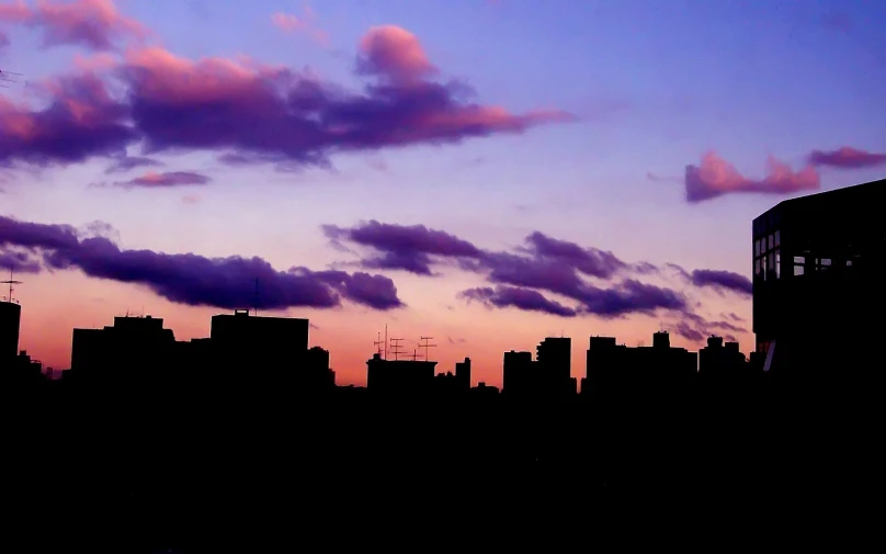 a large building on the side of a city at sunset