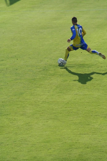 a soccer player runs for the ball on a green field