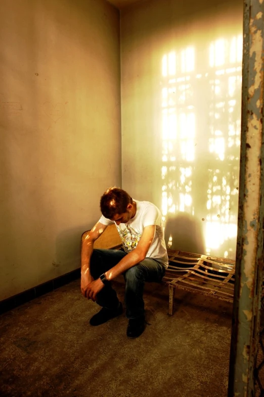 a man is sitting on a bench in the corner of the room