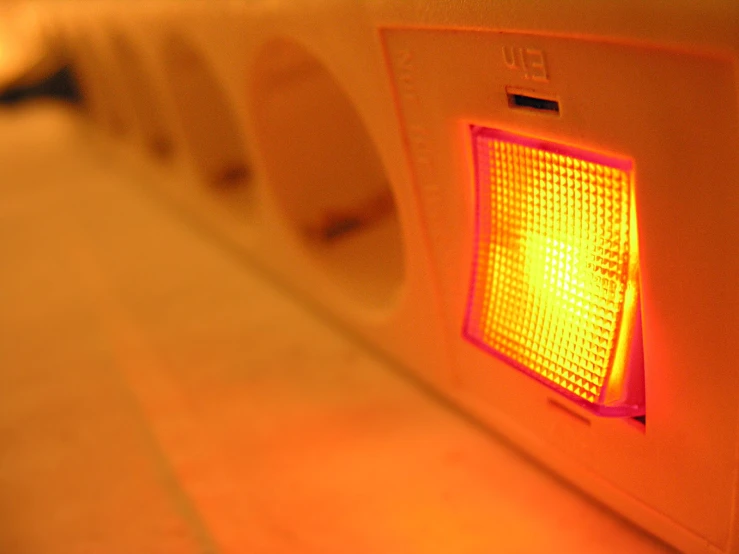 a po of a yellow signal light on a wall