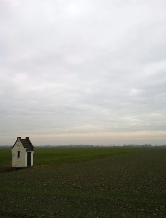 a house in a field with trees in the background