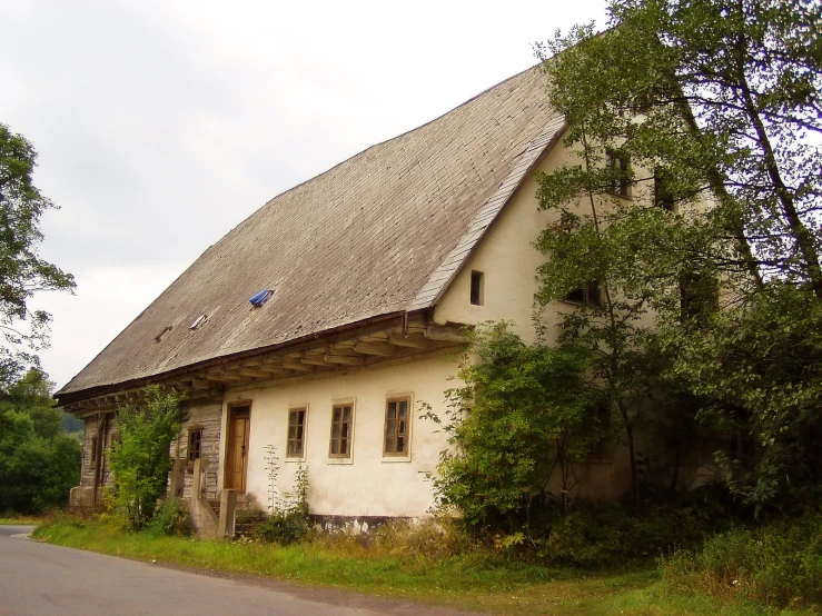 an old farmhouse has a large window and a door