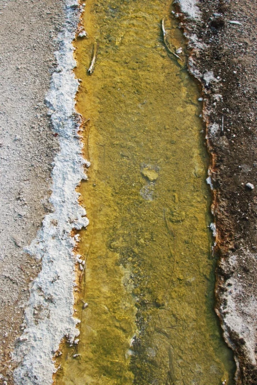 an asphalt road and water is painted with some color