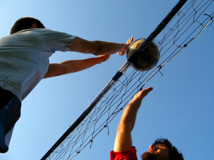 two men reaching into the air to grab a ball