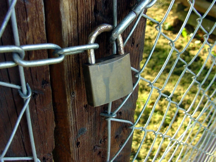 a padlock that is on a wooden gate