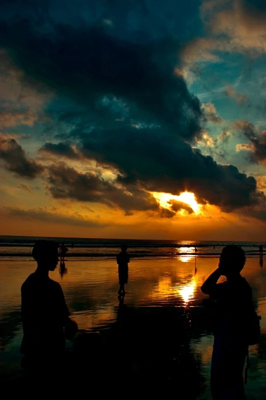 two men are looking out over the water at sunset