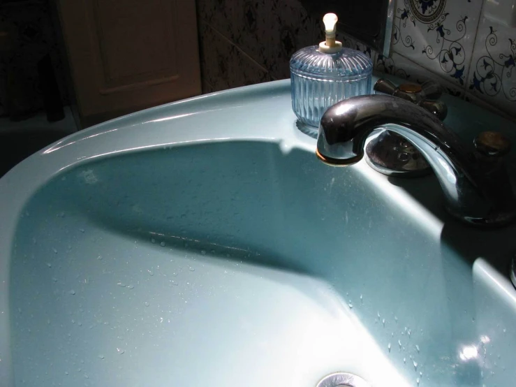 a water faucet sitting next to a sink in a bathroom