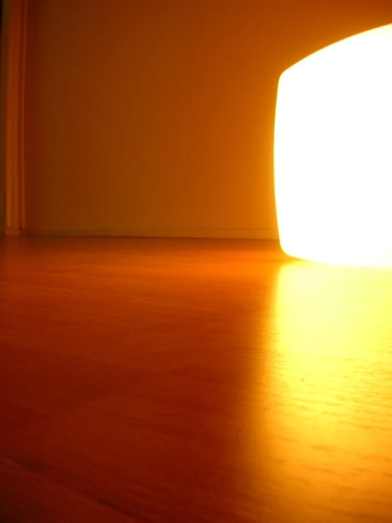 a yellow light shining through the floor with wooden floor