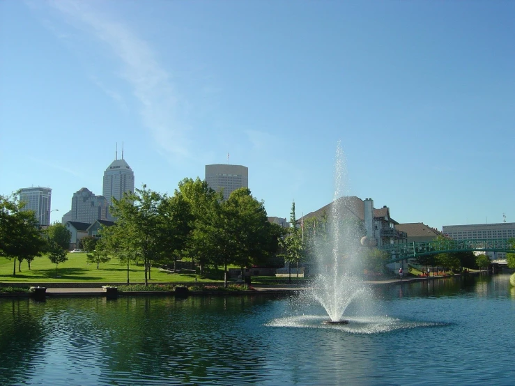 a water fountain with tall buildings in the background