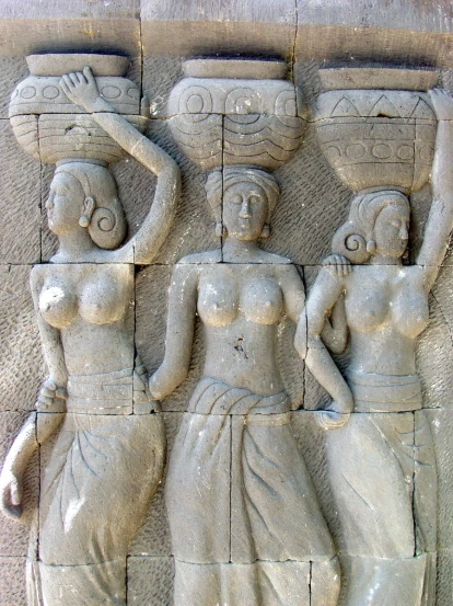 the relief shows two female figures carrying large items