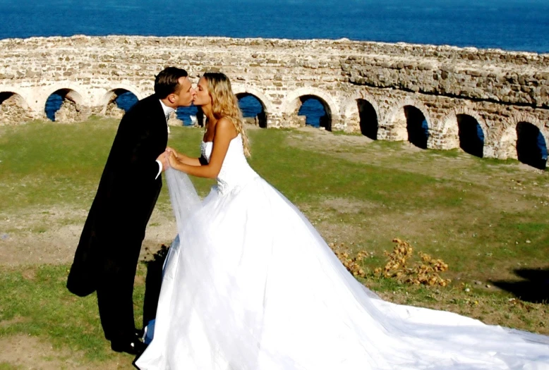 a couple is posing together by the ocean