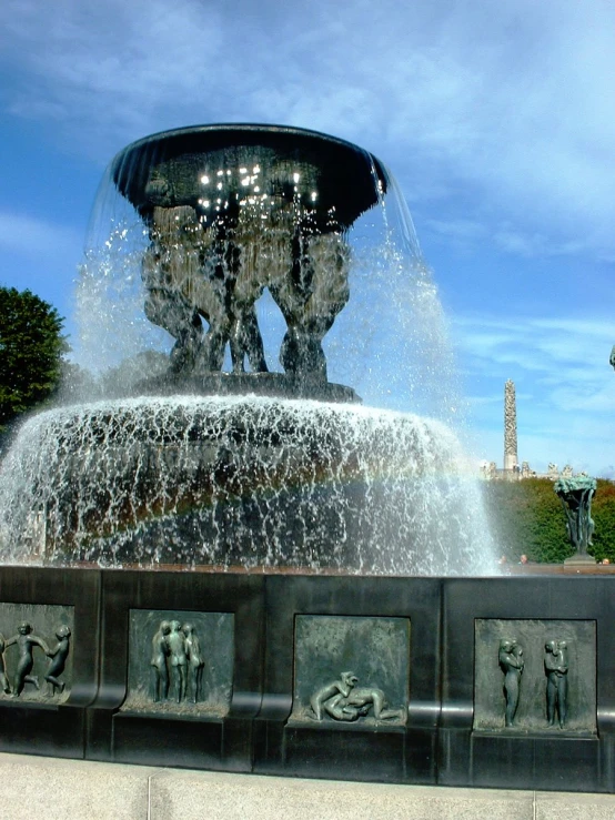 a fountain with people surrounded by small statues
