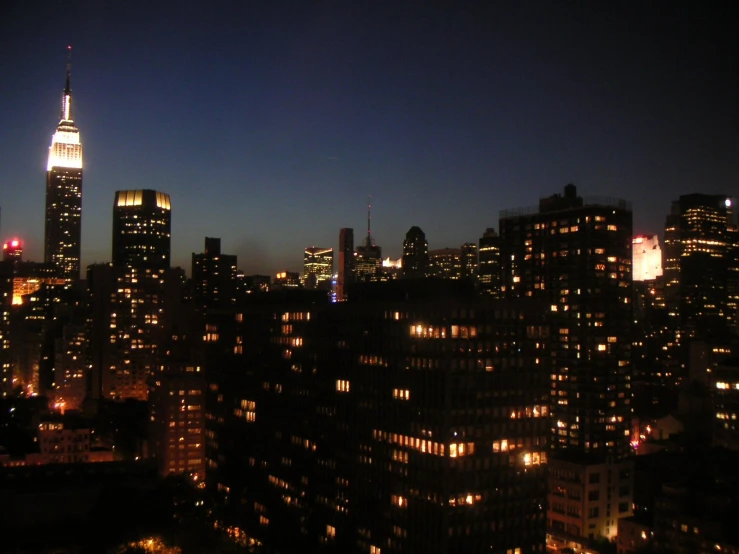 cityscape and skyscrs at night time, with skyscr lit up in the distance