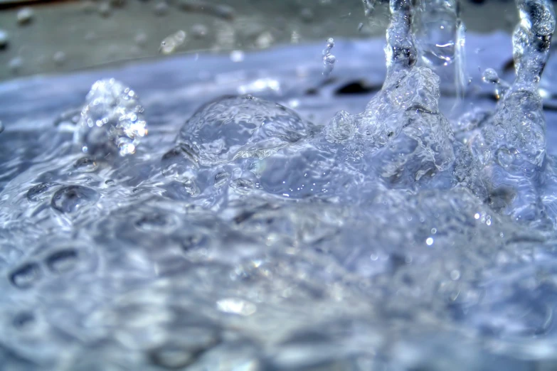 a blue sink filled with water next to a faucet