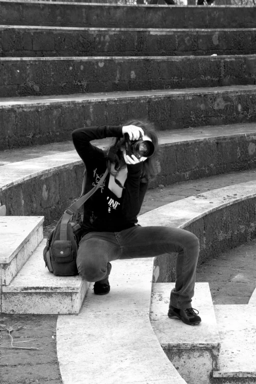 a young man sitting on a handrail and leaning on stairs