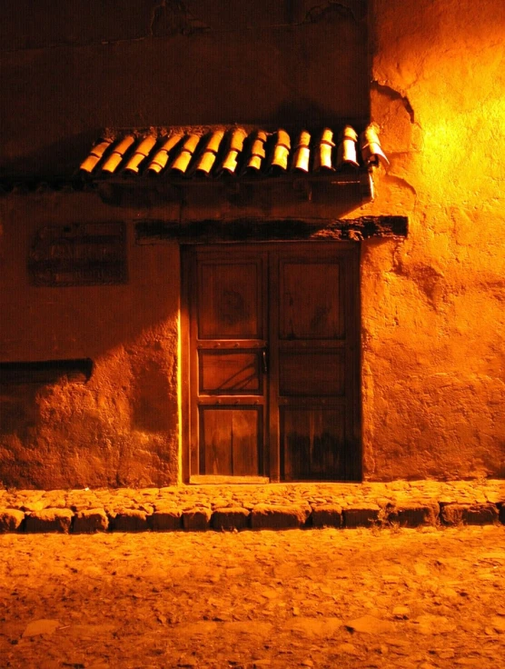 an old door on a building with a light shining down