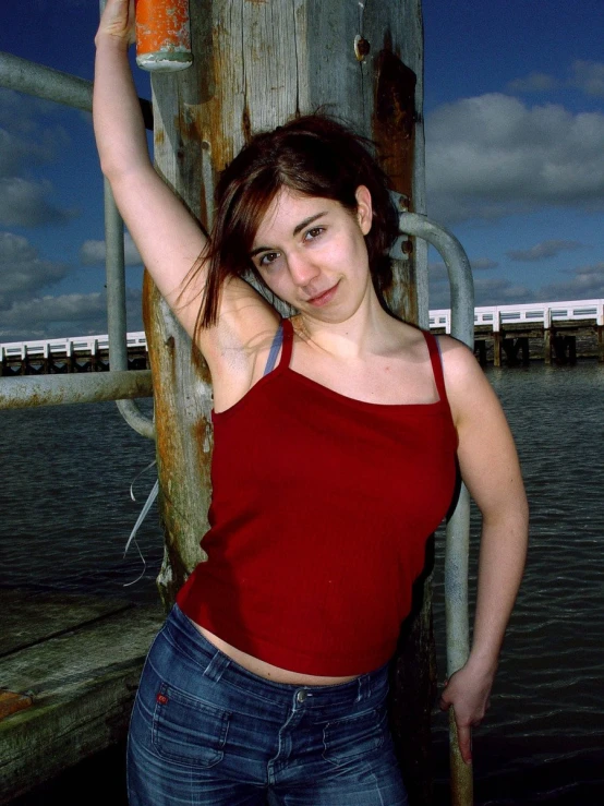 a woman is posing for a pograph by a fence