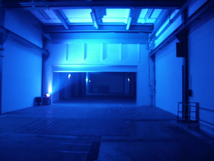 an empty warehouse with blue lights in the middle