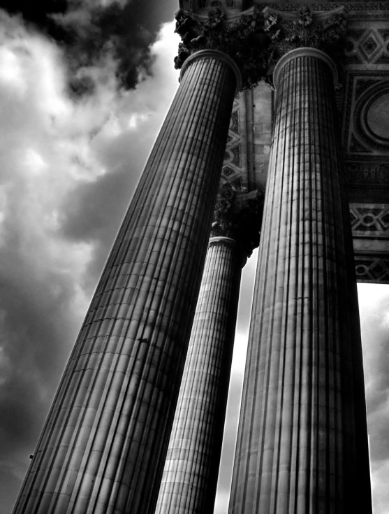 three black and white pillars on a cloudy day