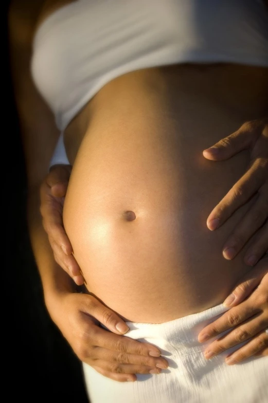 a pregnant person touching her belly with both hands