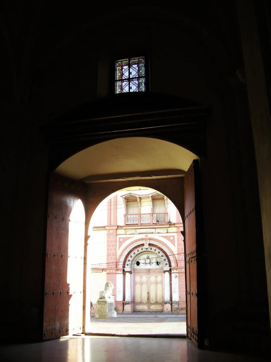 an archway with the doors open leading to a courtyard