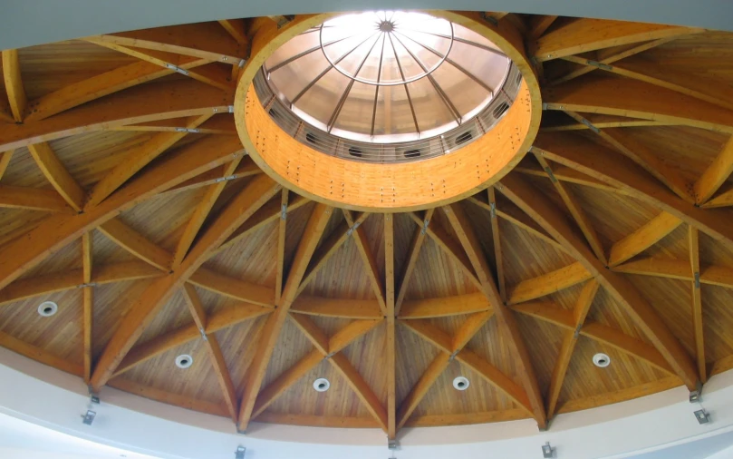 a ceiling with wood shinning and a round skylight